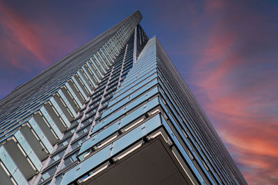 Low angle view of modern building against sky at dusk