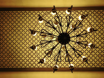 Low angle view of illuminated chandelier hanging on ceiling