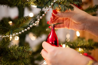 Hanging baubles on the christmas tree, women's tiles, painted nails