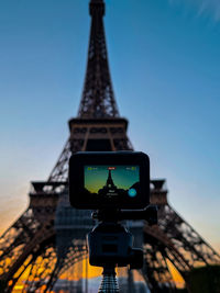 Low angle view of eifel tower with a gopro camera in foreground. 