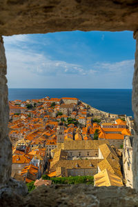 High angle view of townscape by sea against sky