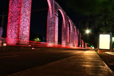 Illuminated light trails on road in city at night