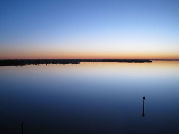 Scenic view of lake against clear blue sky