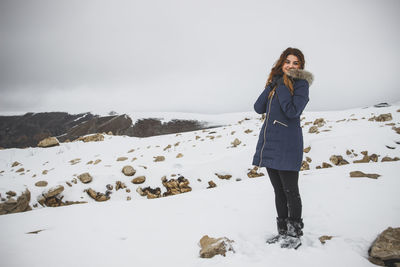 Woman standing on snow covered landscape