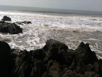 Rock formation in sea against sky