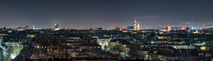 Illuminated buildings in city against sky at night