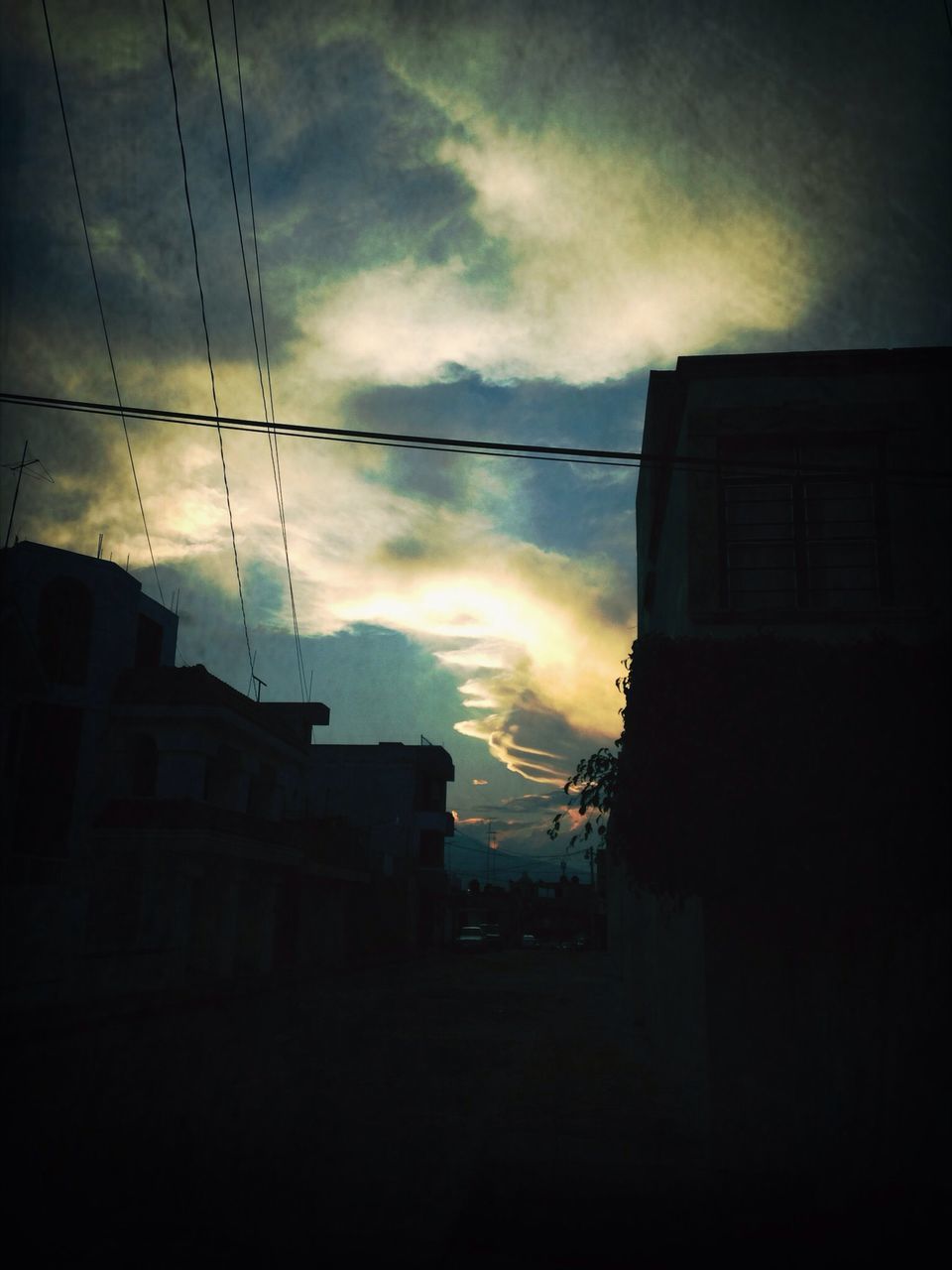 sky, building exterior, architecture, built structure, cloud - sky, sunset, cloudy, silhouette, house, cloud, power line, residential structure, residential building, low angle view, building, dusk, cable, weather, dramatic sky, electricity pylon