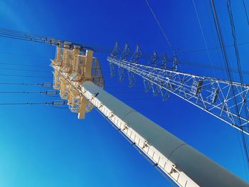 Low angle view of crane against clear blue sky