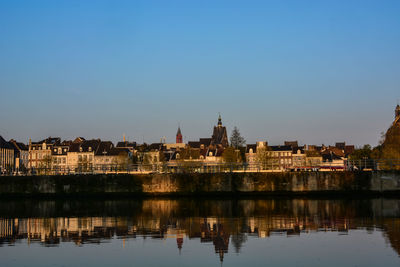 Buildings reflection in lake against blue sky