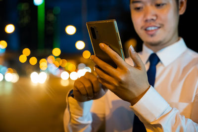 Midsection of businessman using mobile phone