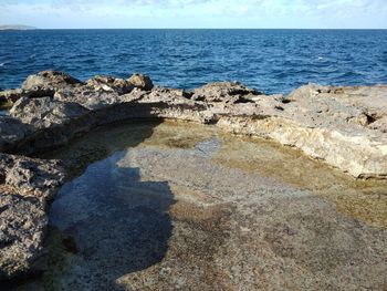 Rocks on beach against sky