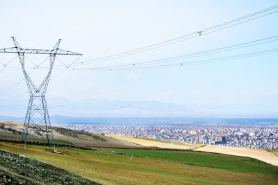 Electricity pylon on field against sky