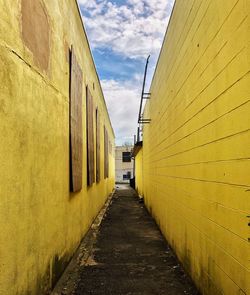 Empty road amidst buildings against sky