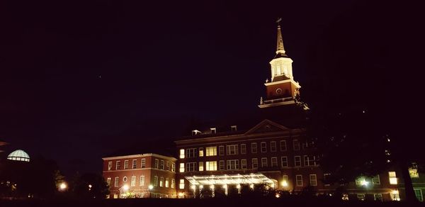 Low angle view of illuminated buildings against sky at night