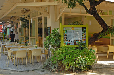 Empty chairs and tables against building