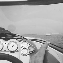 Cropped image of hand holding boat against sea