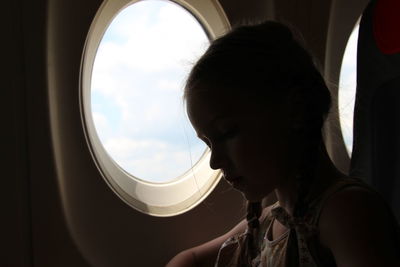Portrait of girl seen through airplane window