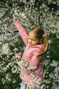 Portrait of young woman standing amidst plants