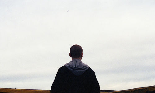 Rear view of man looking against sky