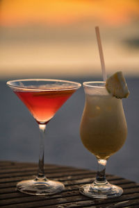 Close-up of cocktails in glasses against sky during sunset