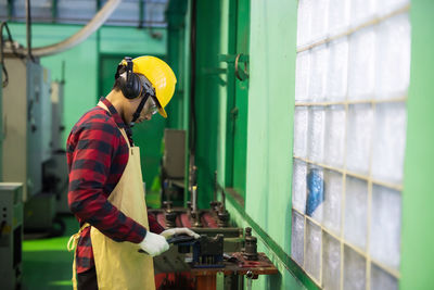 Skill mechanic worker working manual on lathe spare part metal in iron manufacturing factory. 