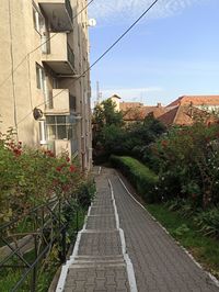 Footpath amidst buildings against sky