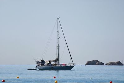 Sailboat sailing on sea against clear sky