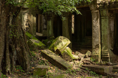 Fallen rocks by statue in temple wall