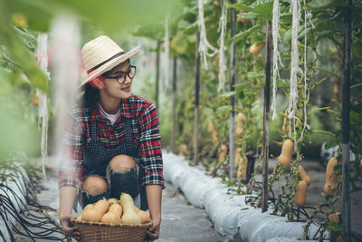 Full length of woman sitting by plants