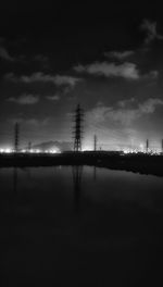 Electricity pylon against cloudy sky