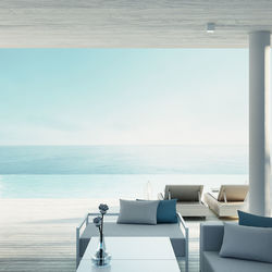 Chairs and table by swimming pool against sky