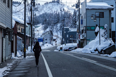 Man walking on street amidst buildings in city