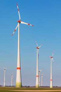 Low angle view of windmill against clear blue sky