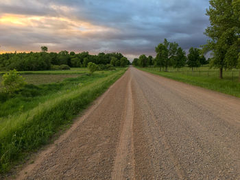 Road amidst field against sky