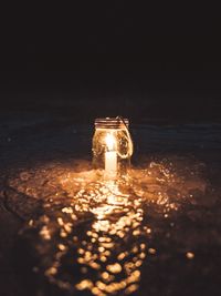 Close-up of illuminated lantern in water at night