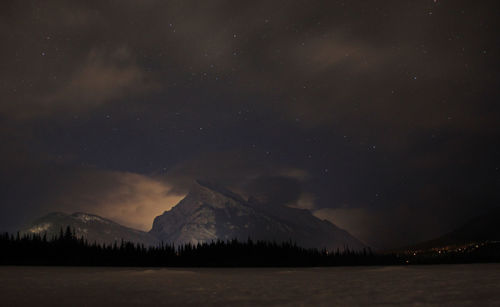 Scenic view of mountains against sky at night