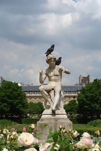 Statue of angel against cloudy sky