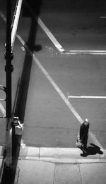 Low section of person walking on road in city