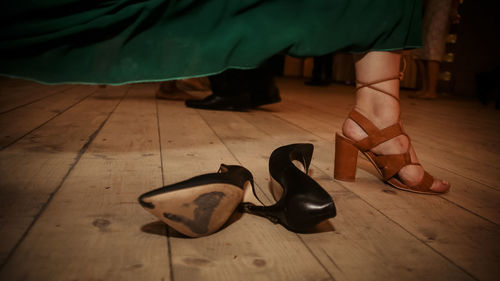 Low section of woman standing on hardwood floor