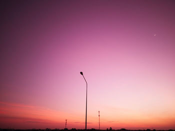 Low angle view of street lights against sky during sunset