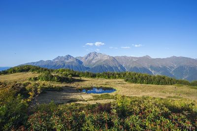 Scenic view of mountains against blue sky