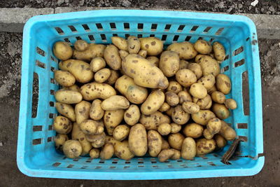 Directly above shot of potatoes in blue basket at market stall