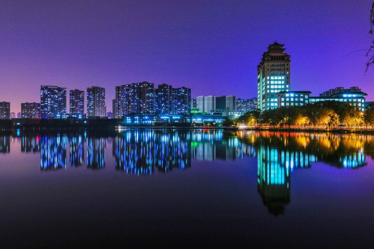 architecture, illuminated, building exterior, skyscraper, built structure, reflection, night, cityscape, city, urban skyline, modern, water, waterfront, sky, no people, outdoors, clear sky