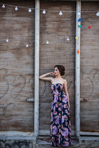 Woman standing against graffiti on wall