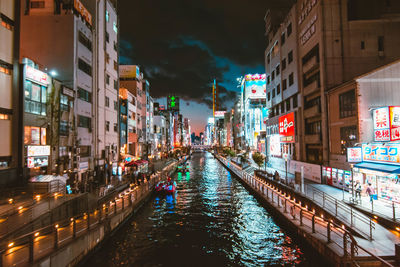 Canal amidst buildings in city at night