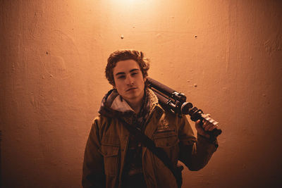 Portrait of young man standing against wall