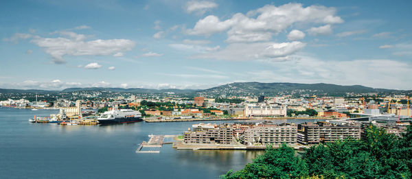 Buildings at waterfront in city against sky