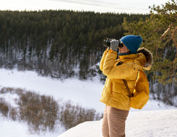 Rear view of man standing on snow covered field