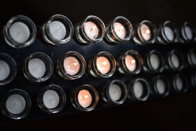 Close-up of illuminated tea lights in darkroom