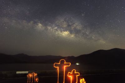 Scenic view of illuminated mountains against sky at night